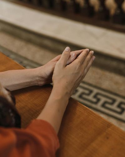 Close-up of a woman's hands in a meditative gesture.